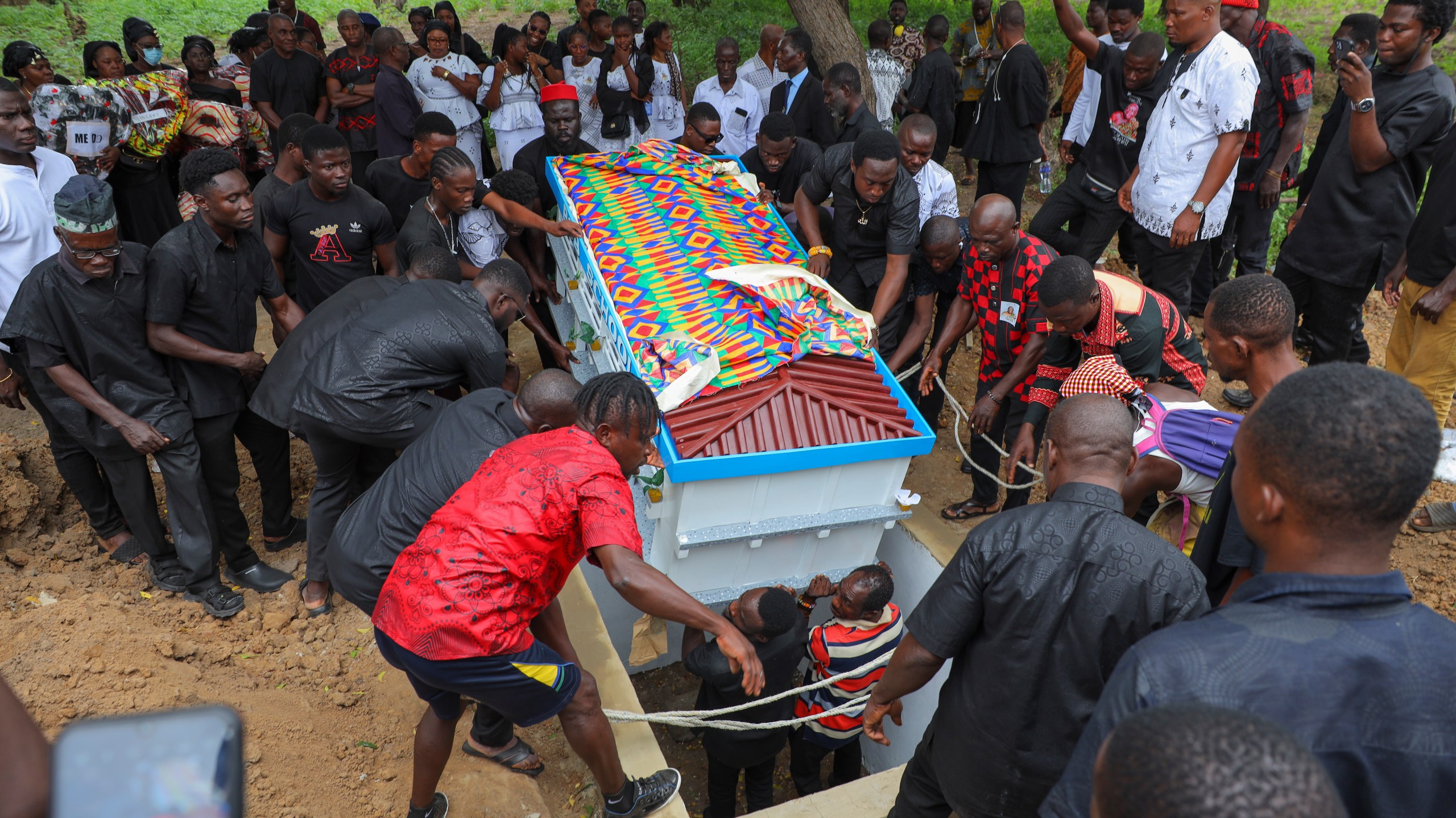 The fantasy coffin of the late Robert Nii Anang Obodai, a former school proprietor, is lowered into his grave in Accra, Ghana, Saturday, July 26, 2025. (AP Photo/Misper Apawu)