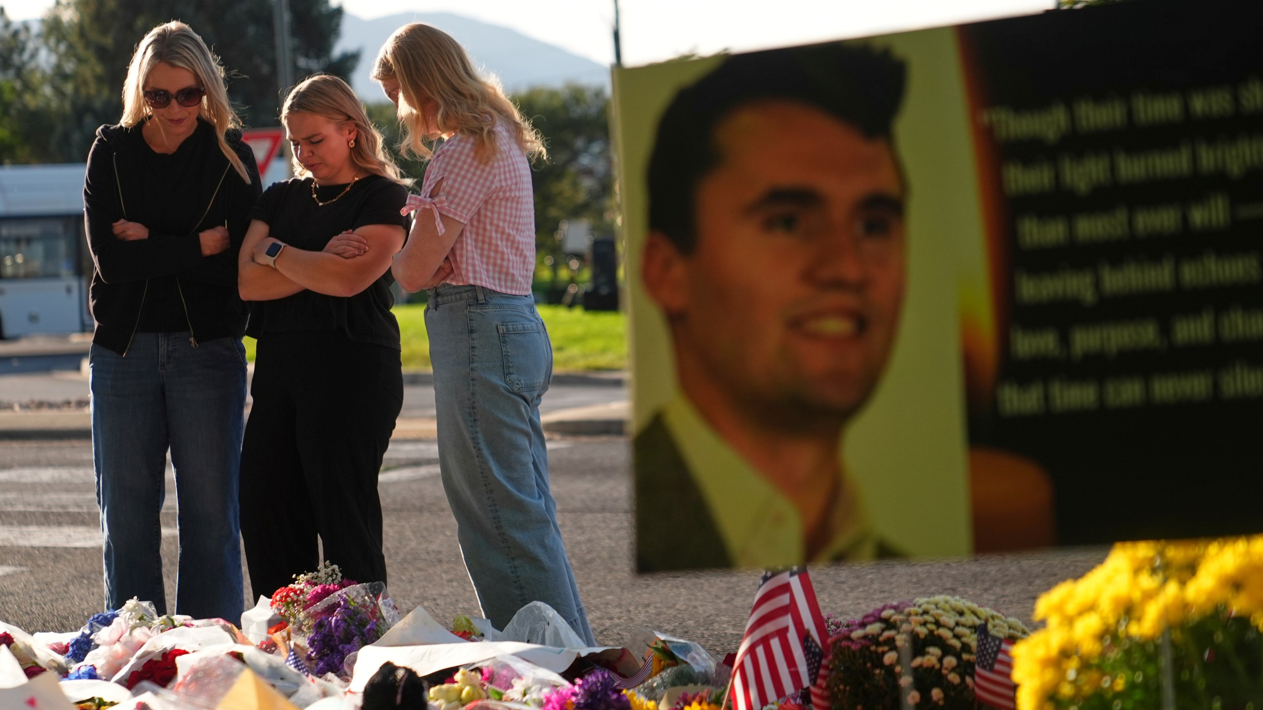 Women pray at a memorial outside Utah Valley University after Turning Point USA CEO and co-founder Charlie Kirk was shot and killed, Saturday, Sept. 13, 2025, in Orem, Utah. (AP Photo/Lindsey Wasson)
