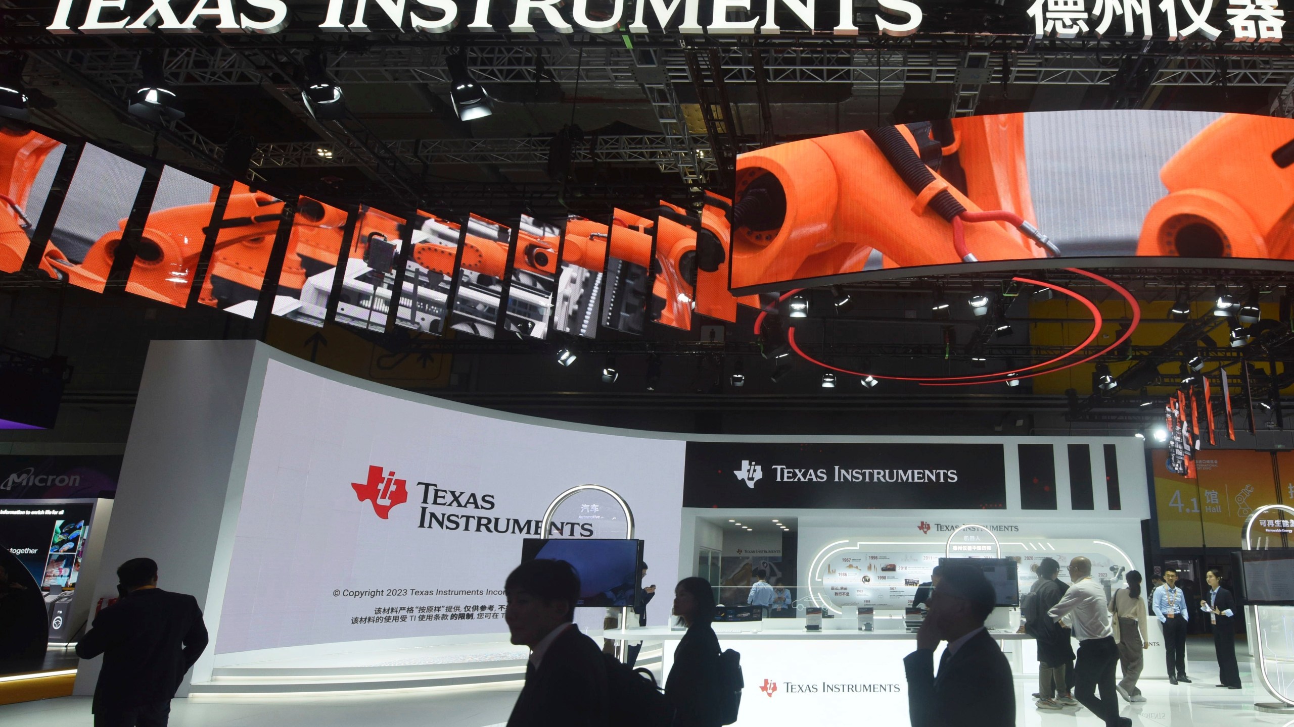 Visitors pass by the booth for Texas Instruments during the China International Imports Expo in Shanghai, China on Nov. 6, 2023. (Chinatopix via AP)