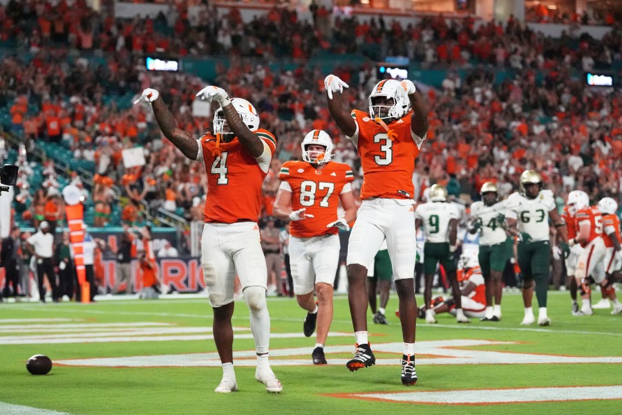 Miami Hurricanes running back Mark Fletcher Jr. (4) celebrates with Miami Hurricanes wide receiver Joshua Moore (3) after scoring a touchdown during the second half of an NCAA college football game against South Florida, Saturday, Sept. 13, 2025, in Miami Gardens, Fla. (AP Photo/Rebecca Blackwell)
