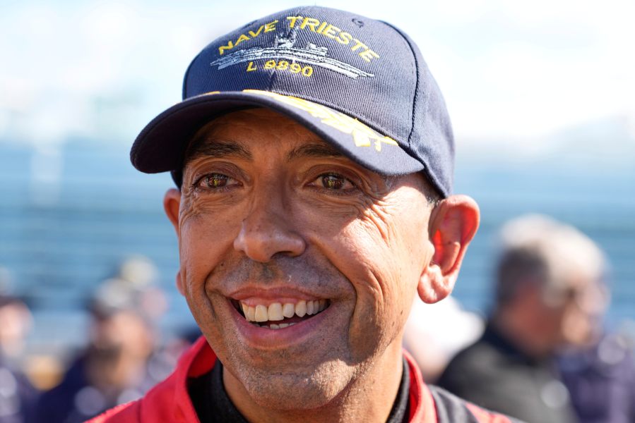 Italian driver Fabio Barone talks to journalists after breaking his own speed record on a ship, at the wheel of a Ferrari SF 90, on the flight deck of the Italian Navy aircraft carrier Nave Trieste, docked at the port of Civitavecchia, Thursday, Sept. 18, 2025. (AP Photo/Gregorio Borgia)