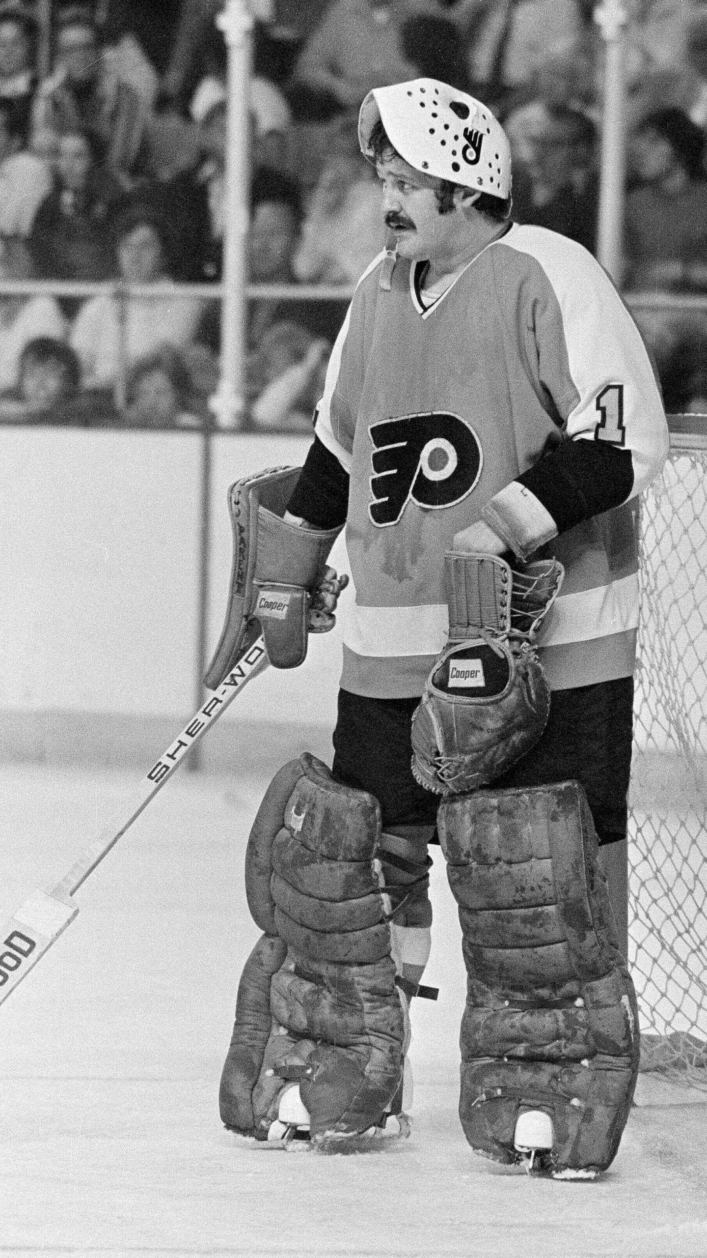 FILE - Philadelphia Flyers goalie Bernie Parent raises his mask to take a break during the Stanley Cup finals in Buffalo, N.Y., May 28, 1975, against the Buffalo Sabres. (AP Photo, File)