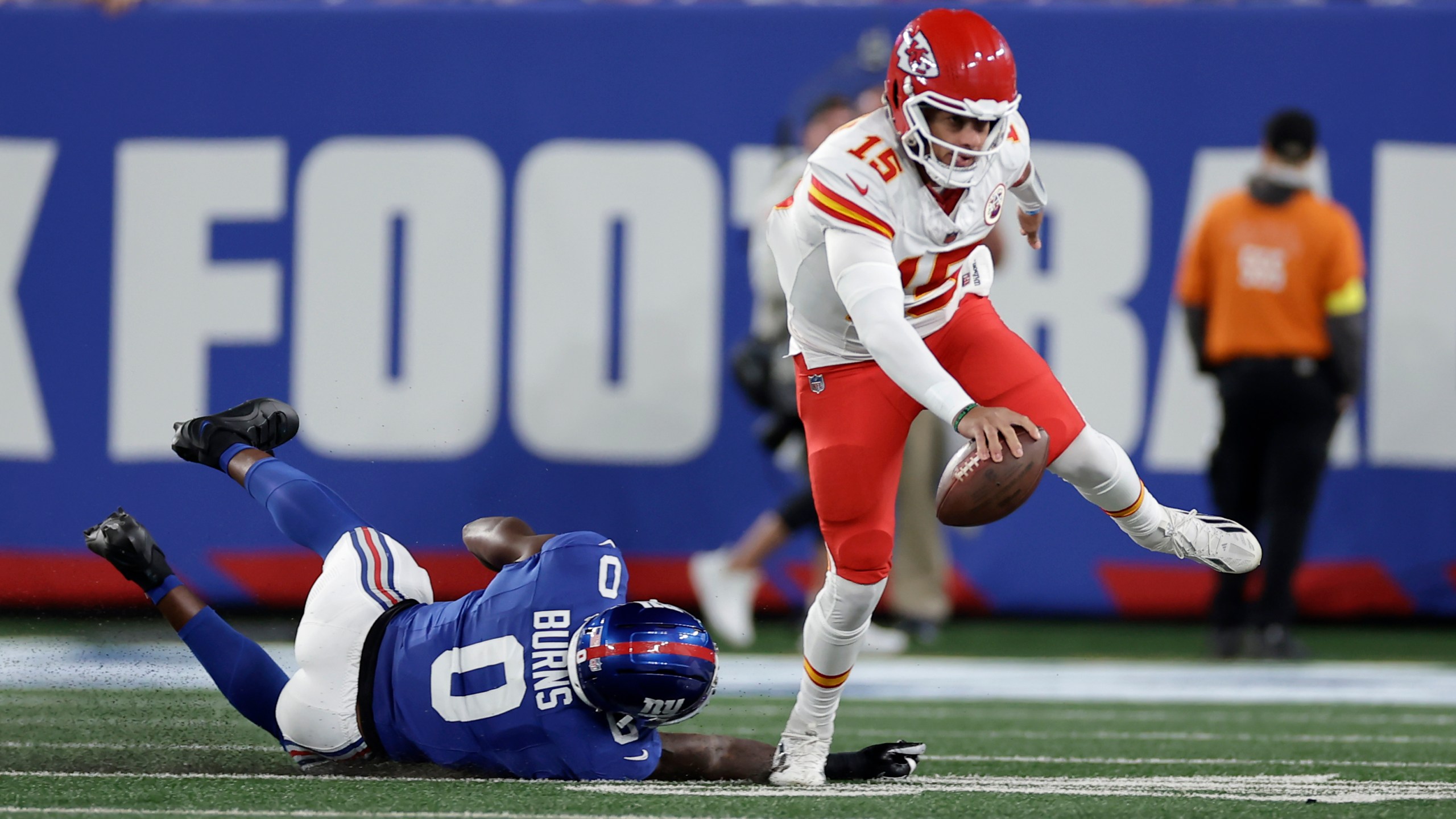 Kansas City Chiefs quarterback Patrick Mahomes (15) scrambles away from New York Giants outside linebacker Brian Burns (0) during the first half of an NFL football game Sunday, Sept. 21, 2025, in East Rutherford, N.J. (AP Photo/Adam Hunger)