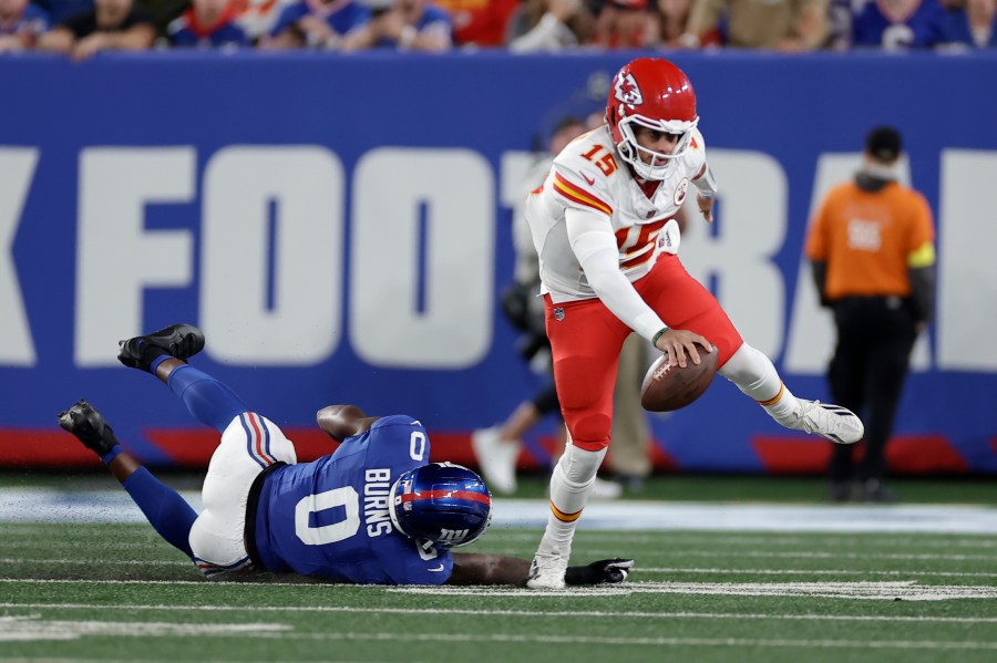 Kansas City Chiefs quarterback Patrick Mahomes (15) scrambles away from New York Giants outside linebacker Brian Burns (0) during the first half of an NFL football game Sunday, Sept. 21, 2025, in East Rutherford, N.J. (AP Photo/Adam Hunger)