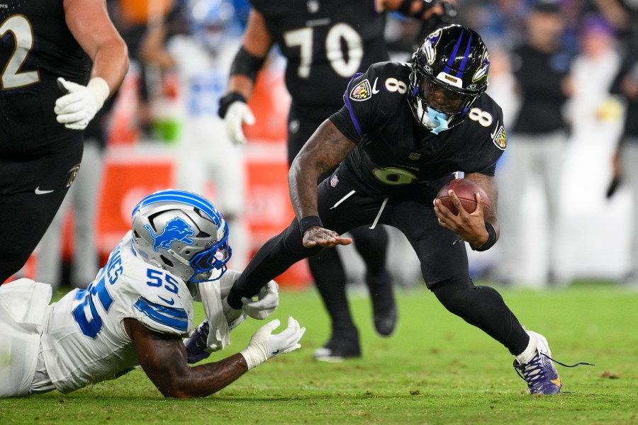 Baltimore Ravens quarterback Lamar Jackson (8) is tripped up by Detroit Lions linebacker Derrick Barnes (55) during the second half of an NFL football game Monday, Sept. 22, 2025, in Baltimore. (AP Photo/Nick Wass)
