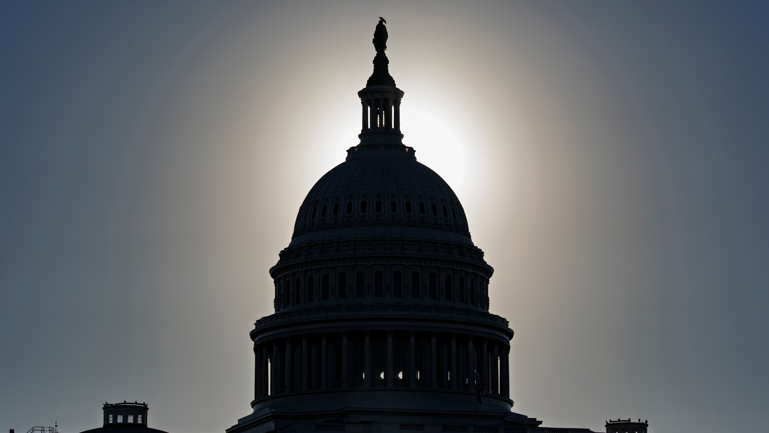 The U.S. Capitol is silhouetted by the stark glare of the morning sun as a government shutdown begins its tenth day, in Washington, Friday, Oct. 10, 2025. (AP Photo/J. Scott Applewhite)