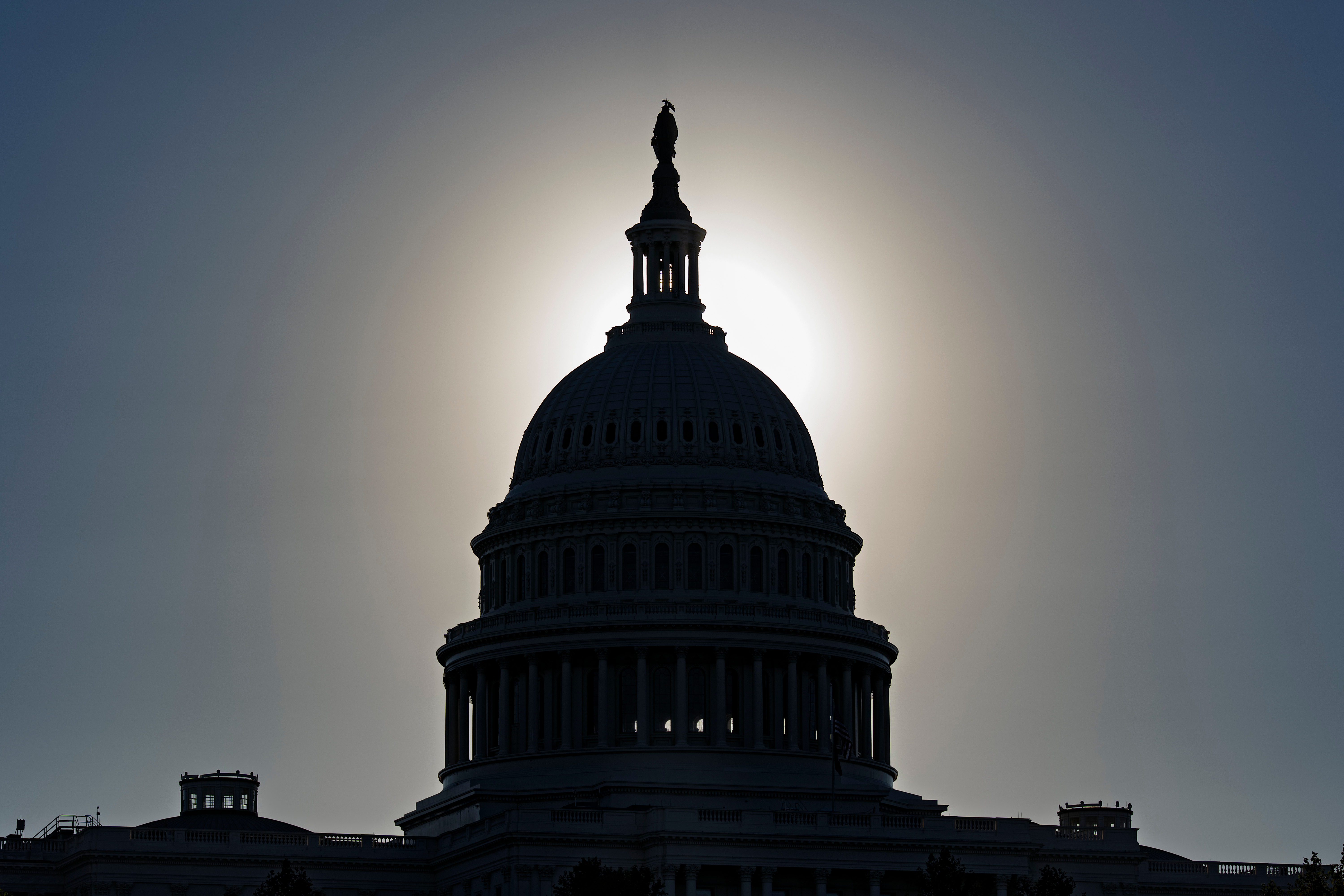 The U.S. Capitol is silhouetted by the stark glare of the morning sun as a government shutdown begins its tenth day, in Washington, Friday, Oct. 10, 2025. (AP Photo/J. Scott Applewhite)