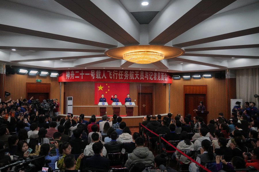 Astronauts for the upcoming Shenzhou 21 mission, from left, Zhang Hongzhang, Zhang Lu and Wu Fei arrive for a meeting with the press at the Jiuquan Satellite Launch Center in Jiuquan, northwest China, Thursday, Oct. 30, 2025. (AP Photo/Andy Wong)
