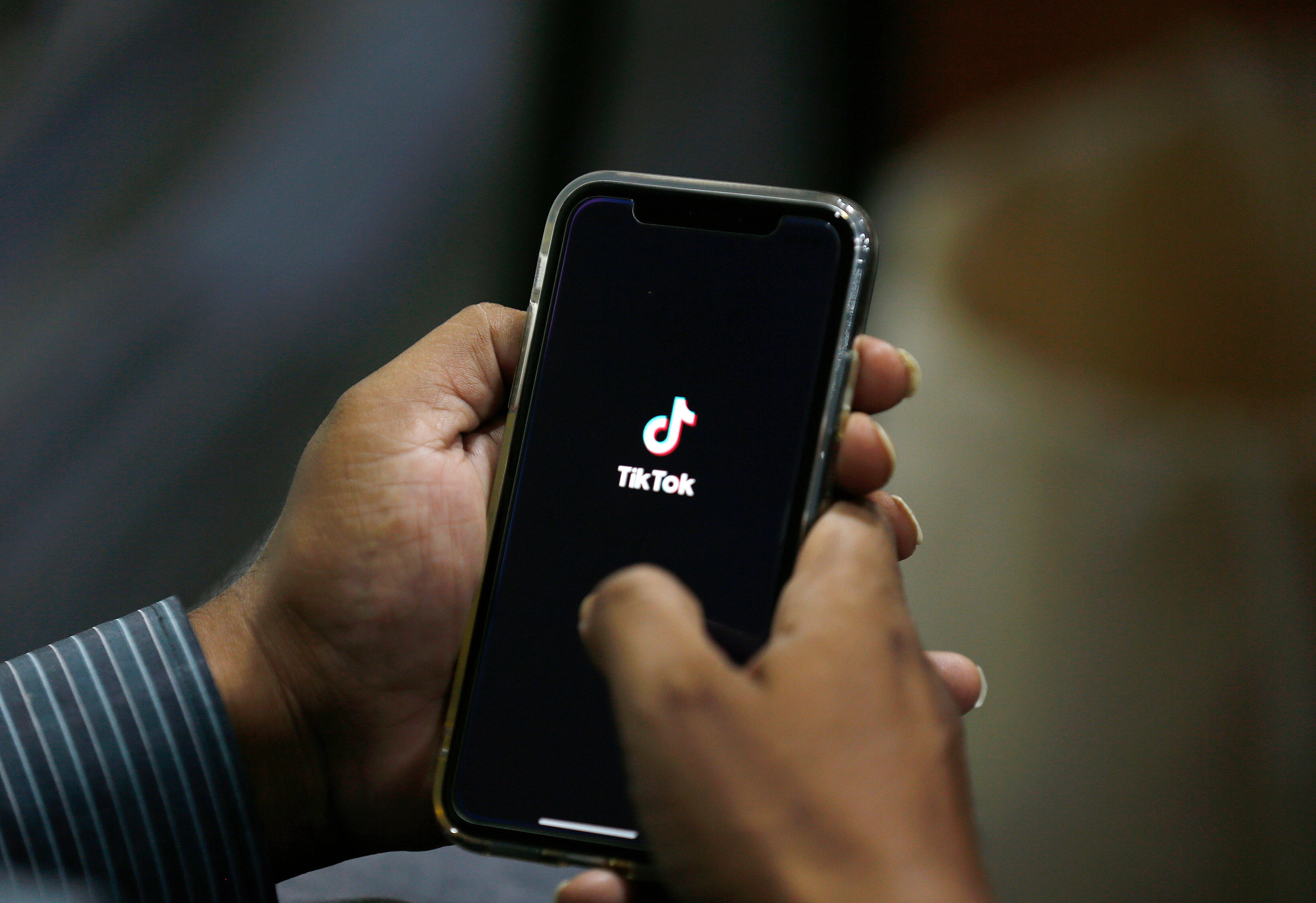 FILE - In this July 21, 2020 file photo, a man opens social media app 'TikTok' on his cell phone, in Islamabad, Pakistan. (AP Photo/Anjum Naveed, File)