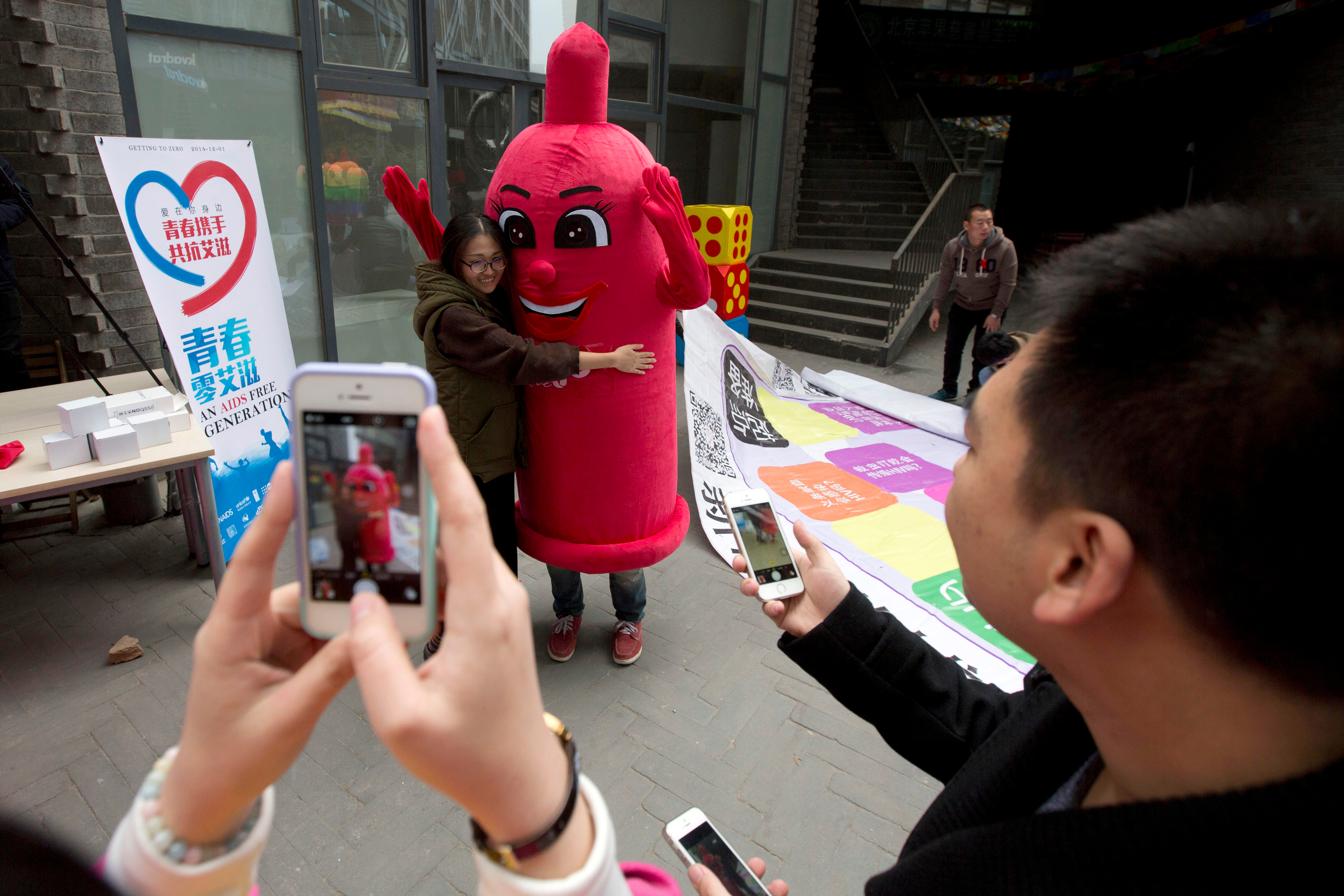 FILE - A participant hugs a condom mascot during an event to promote awareness of HIV testing ahead of the Dec 1 World AIDS Day, in Beijing, China, Thursday, Nov. 27, 2014. (AP Photo/Ng Han Guan, File)