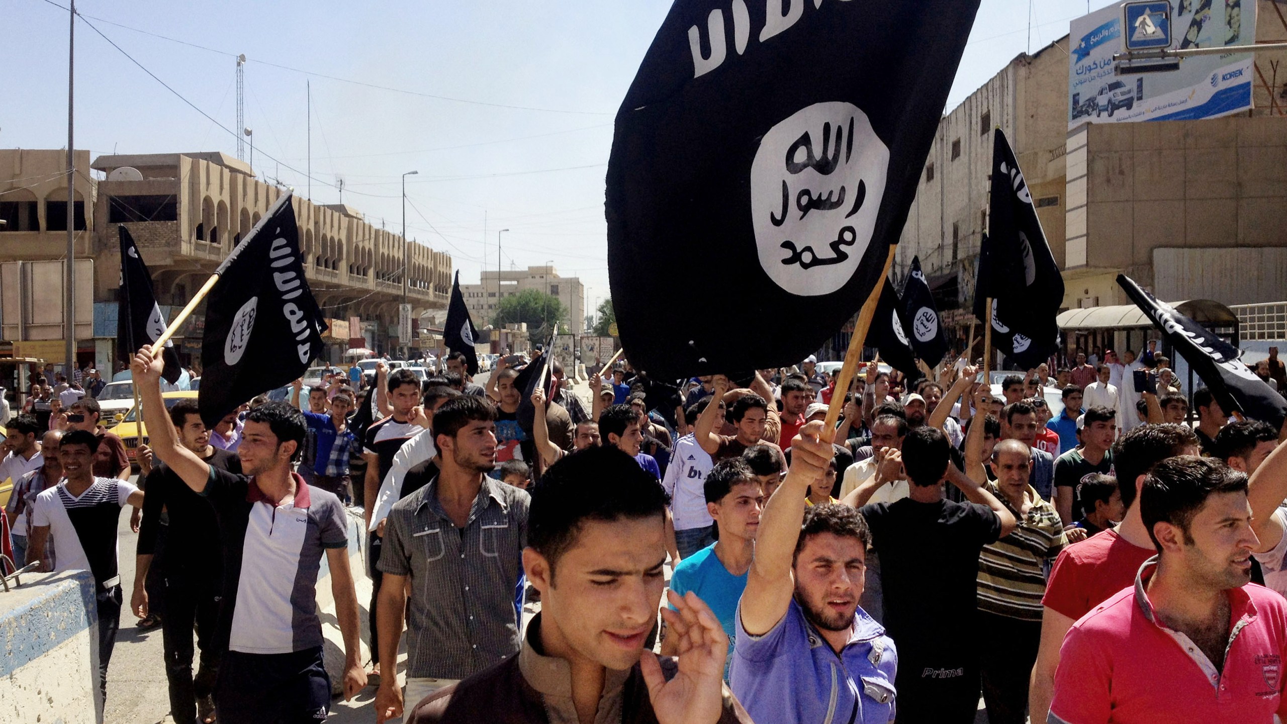 FILE - Demonstrators chant pro-Islamic State slogans as they carry the group's flags in front of the provincial government headquarters in Mosul, 225 miles (360 kilometers) northwest of Baghdad on June 16, 2014. (AP Photo, File)