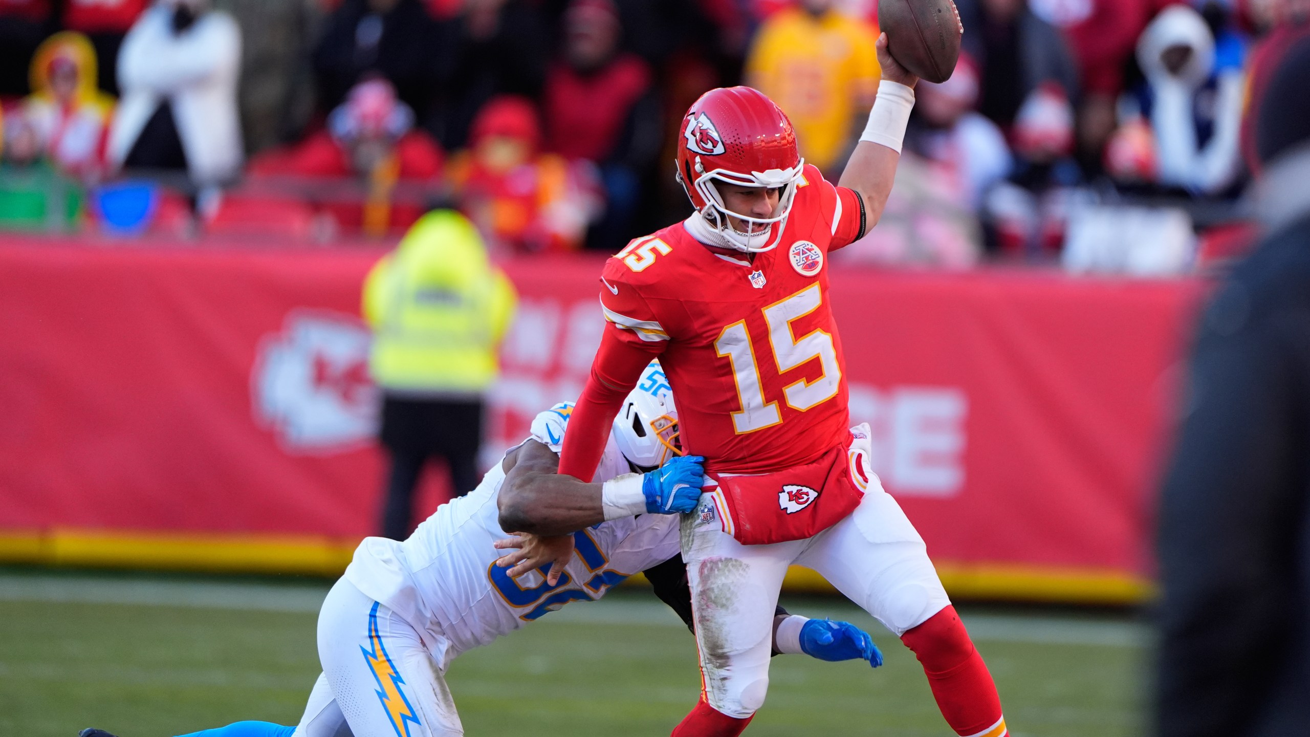 Kansas City Chiefs quarterback Patrick Mahomes (15) is pushed out of bounds by Los Angeles Chargers outside linebacker Khalil Mack, left, during the second half of an NFL football game Sunday, Dec. 14, 2025, in Kansas City, Mo. (AP Photo/Charlie Riedel)