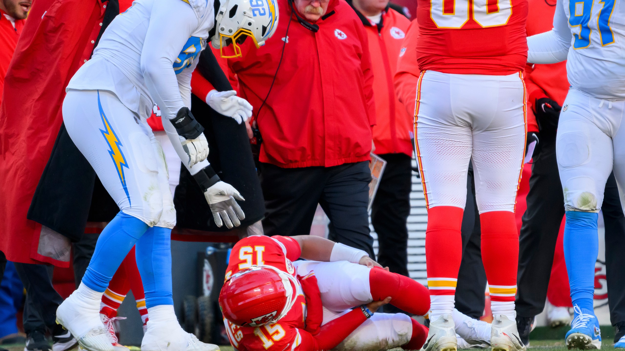 Los Angeles Chargers defensive tackle Justin Eboigbe (92) checks on Kansas City Chiefs quarterback Patrick Mahomes (15) as Chiefs head coach Andy Reid, center, looks on after Mahomes was injured during the second half of an NFL football game, Sunday, Dec. 14, 2025 in Kansas City, Mo. (AP Photo/Reed Hoffmann)