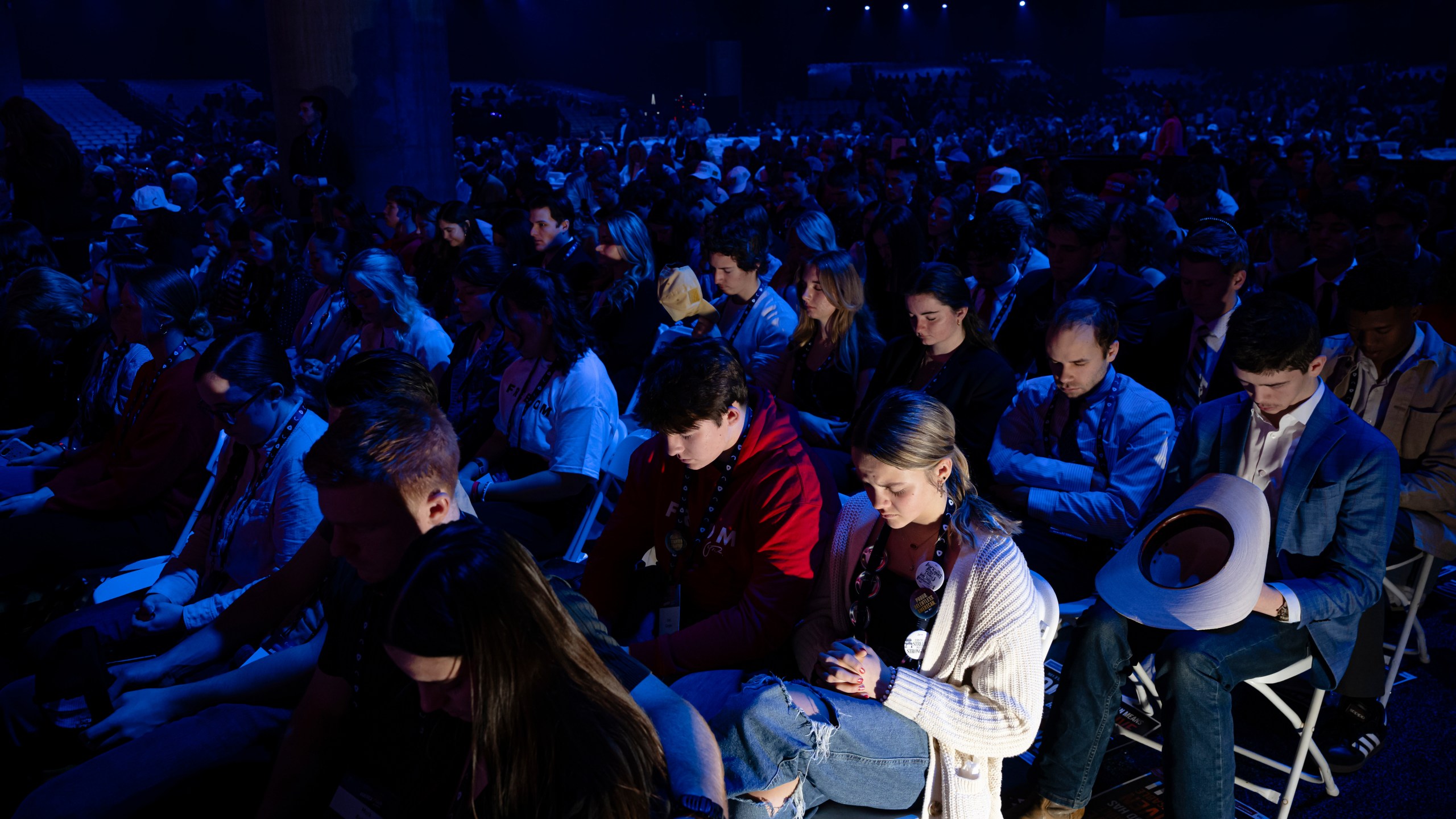 Attendees sit in prayer during Turning Point USA's AmericaFest 2025, Saturday, Dec. 20, 2025, in Phoenix. (AP Photo/Jon Cherry)