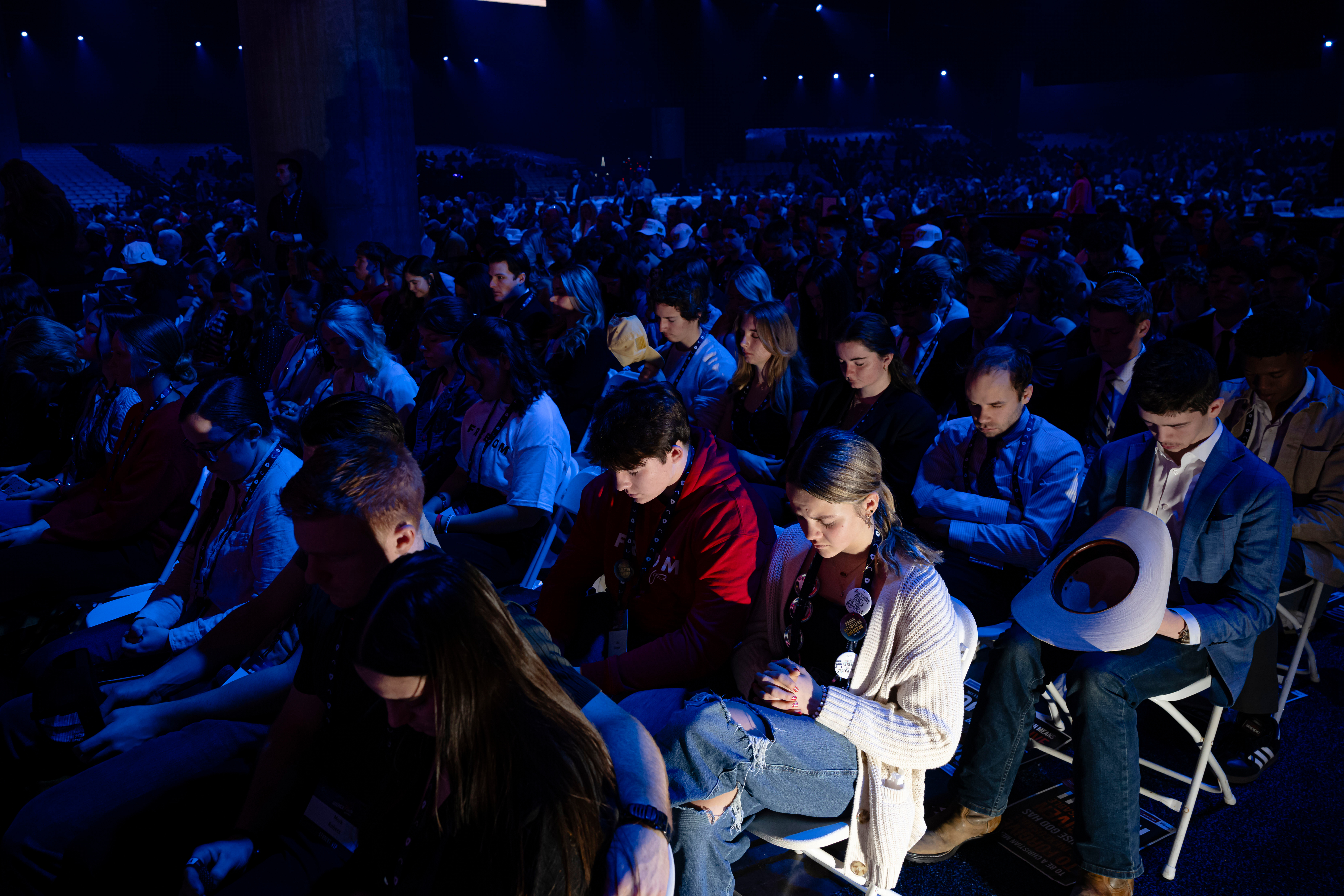 Attendees sit in prayer during Turning Point USA's AmericaFest 2025, Saturday, Dec. 20, 2025, in Phoenix. (AP Photo/Jon Cherry)